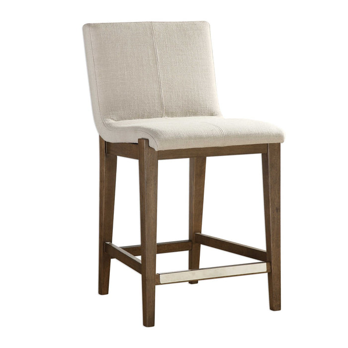 Brown armless counter stool with cream cushion.