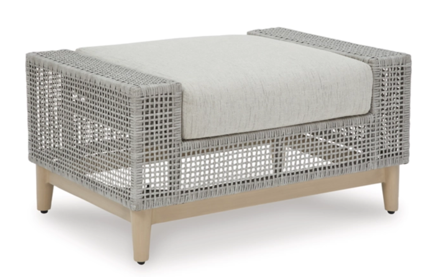 Angled view of gray woven footrest with cream cushion.