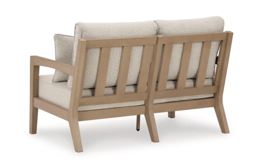 Back of two seat patio bench with cream cushions.