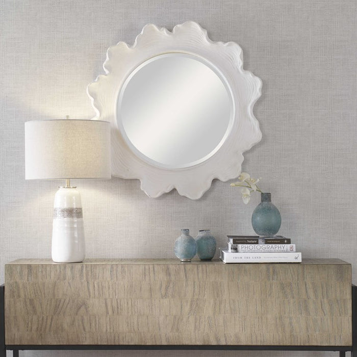 White round flower mirror on wall.