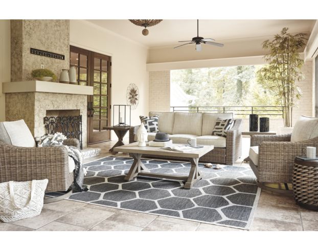 Angled view of cream and beige furnished living room with fireplace.