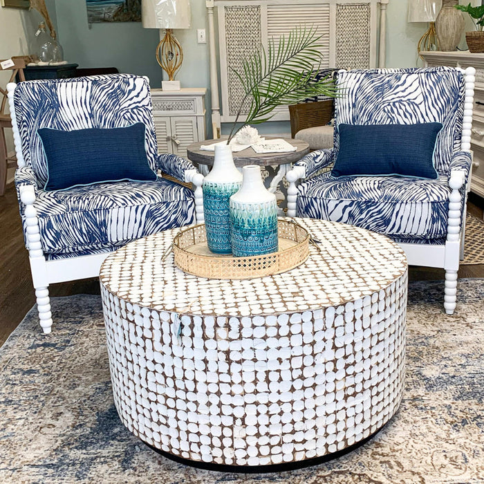 Small dining room furniture, including a round table and white and blue chairs.