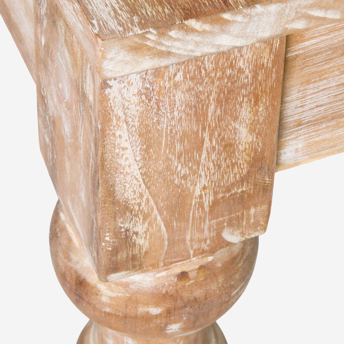 Close up of corner of rustic light brown dining table.