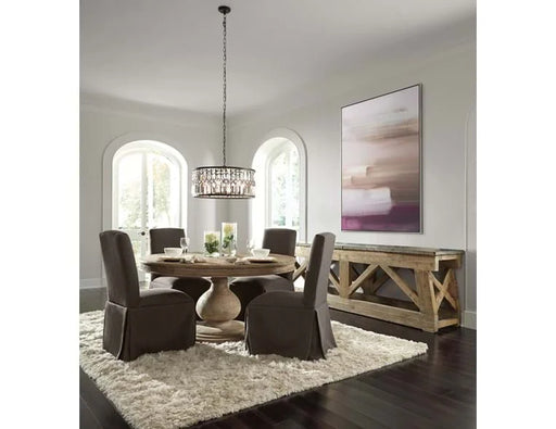 Angled view of dining room with round dining table and brown fabric chairs.