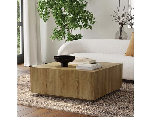 Room with white rounded back couch and square brown coffee table.