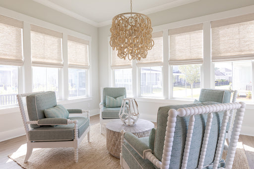Coastal sunroom with dangling chandelier and patio furniture.