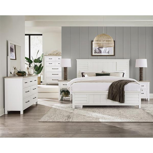 Coastal bedroom with gray accent wall and white furniture.