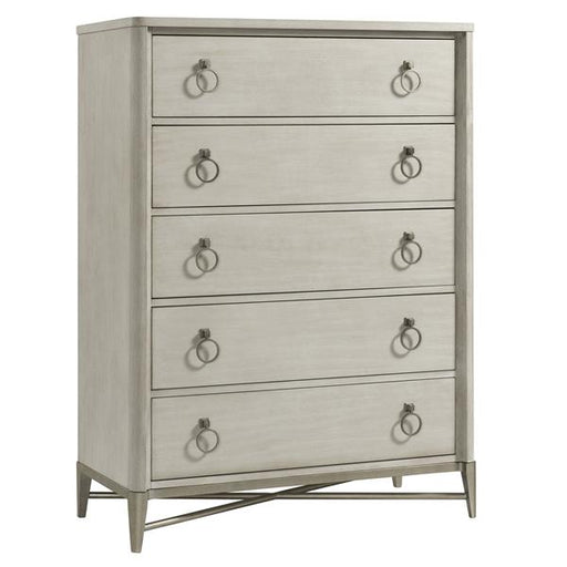 Angled view of cream five drawer dresser with round gold pulls.
