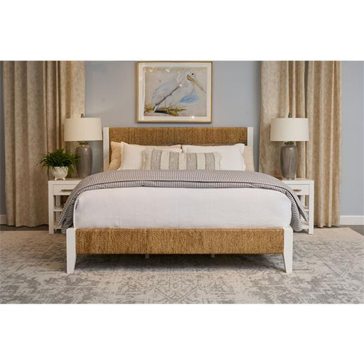 Carpeted light blue bedroom with white and brown bed, side tables, and lamps.
