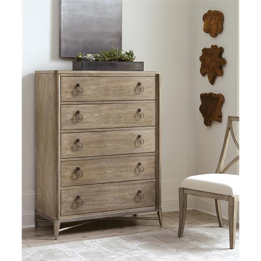 Angled view of brown gray five drawer dresser in bedroom.