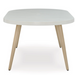 Front of oval white dining table with brown legs angled outward.