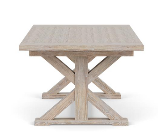 Side view of light brown wood dining table with X style legs.