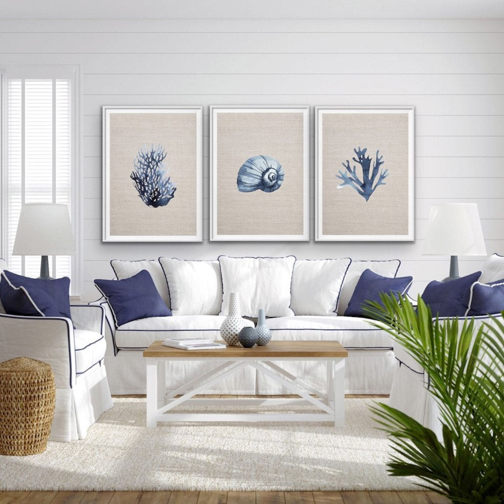 A white living room set with blue accents, including upholstered furniture and decorative pillows.