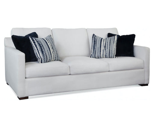 Angled view of white three seat couch with blue accent pillows.