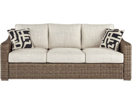 Front of brown wicker three seat exterior couch with cream cushions.