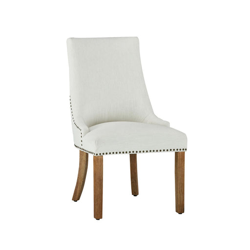 Elegant dining room furniture featuring a white fabric dining chair with rivet accents.