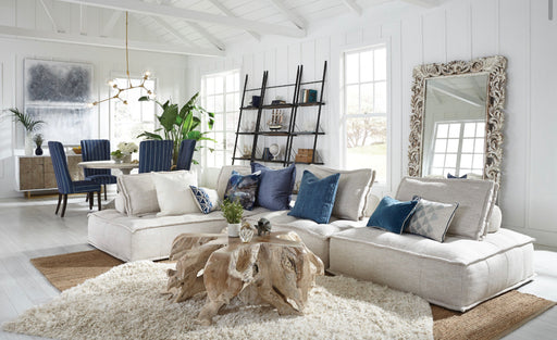 White coastal living room with navy blue accents and driftwood table.