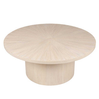 Low sand-colored round coffee table.