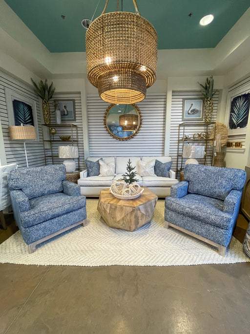 White living room with medium blue chairs and light brown angular table.