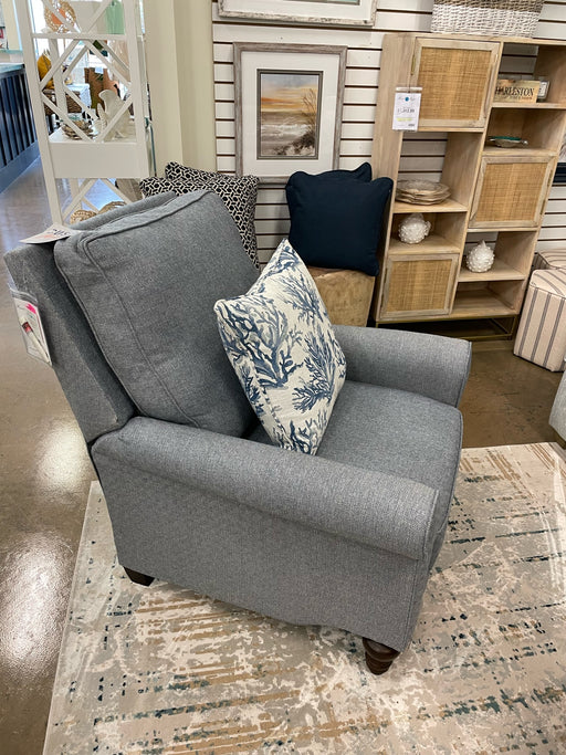 Diagonal view of dark gray arm chair with white and blue pillow.