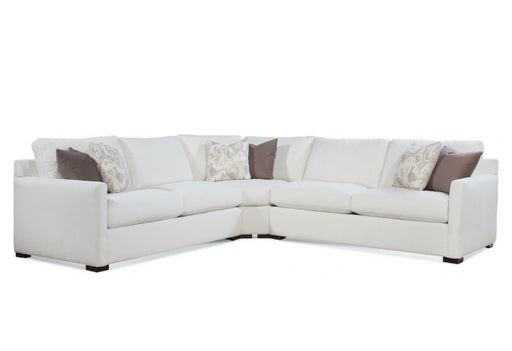 Angled view of large white sectional with brown and beige pillows.