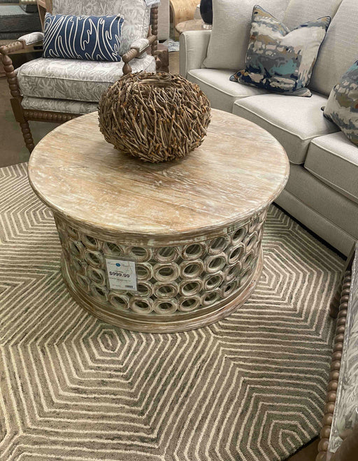Small light brown round coffee/accent table in showroom.