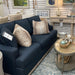 Dark navy sofa in room with wallpaper and wallcoverings.